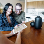 Couple in Newcastle reviewing a property contract with their lawyer before purchase