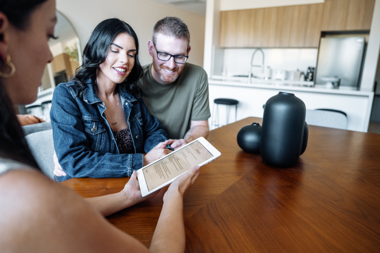 Couple in Newcastle reviewing a property contract with their lawyer before purchase