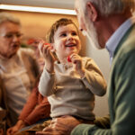 randfather smiling while talking to young grandson in relaxed family setting