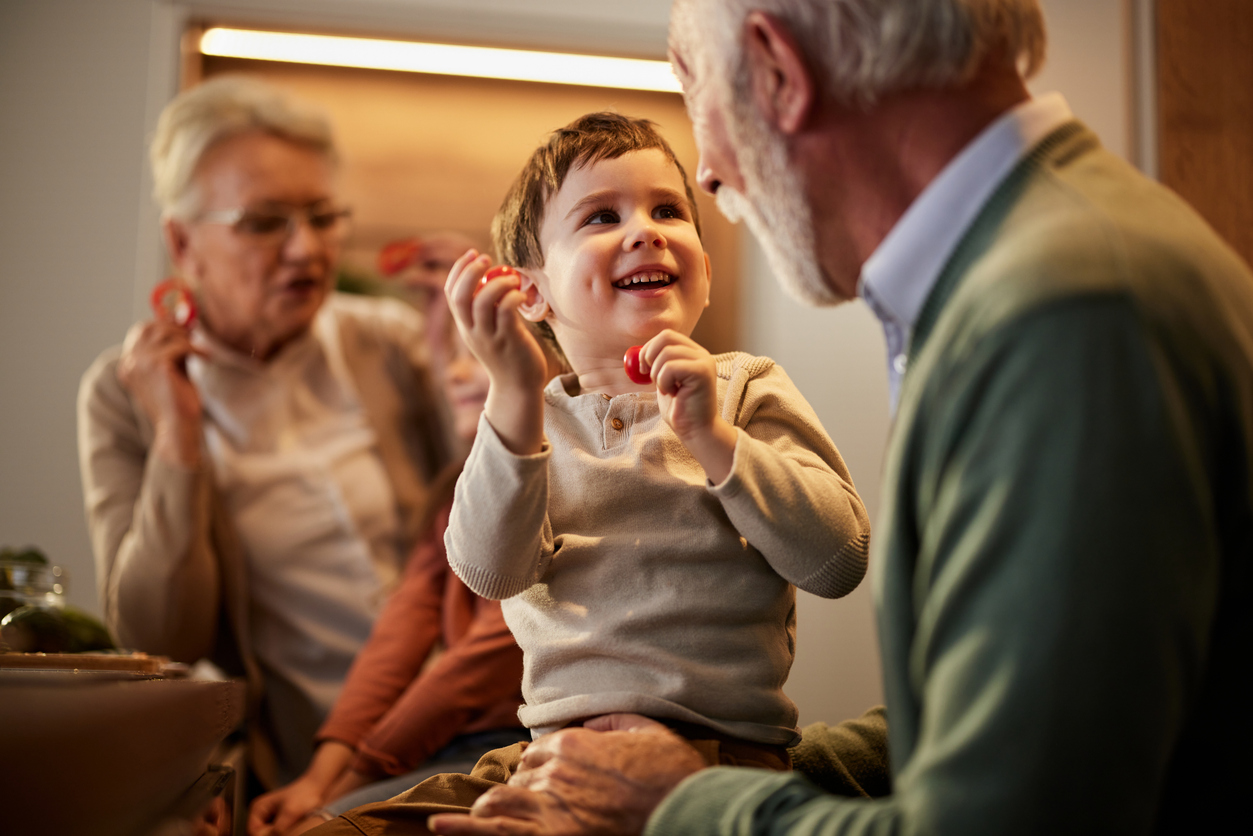 randfather smiling while talking to young grandson in relaxed family setting